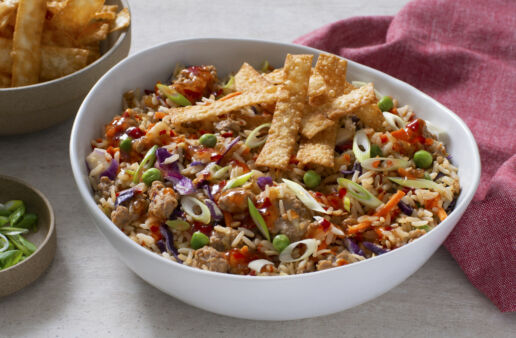 eggroll in a bowl with wonton strips shredded cabbage chili sauce sesame oil and ground pork
